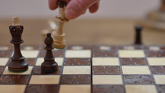 白皇后的慢动作镜头通过黑国王国际象棋与主教检查交配视频的预览图