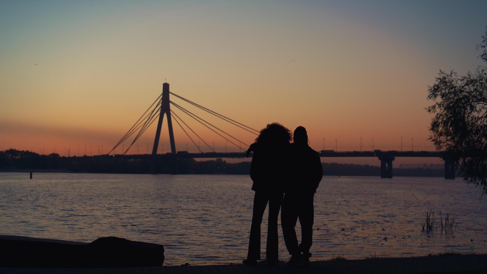 情人在河岸看日落的剪影视频的预览图