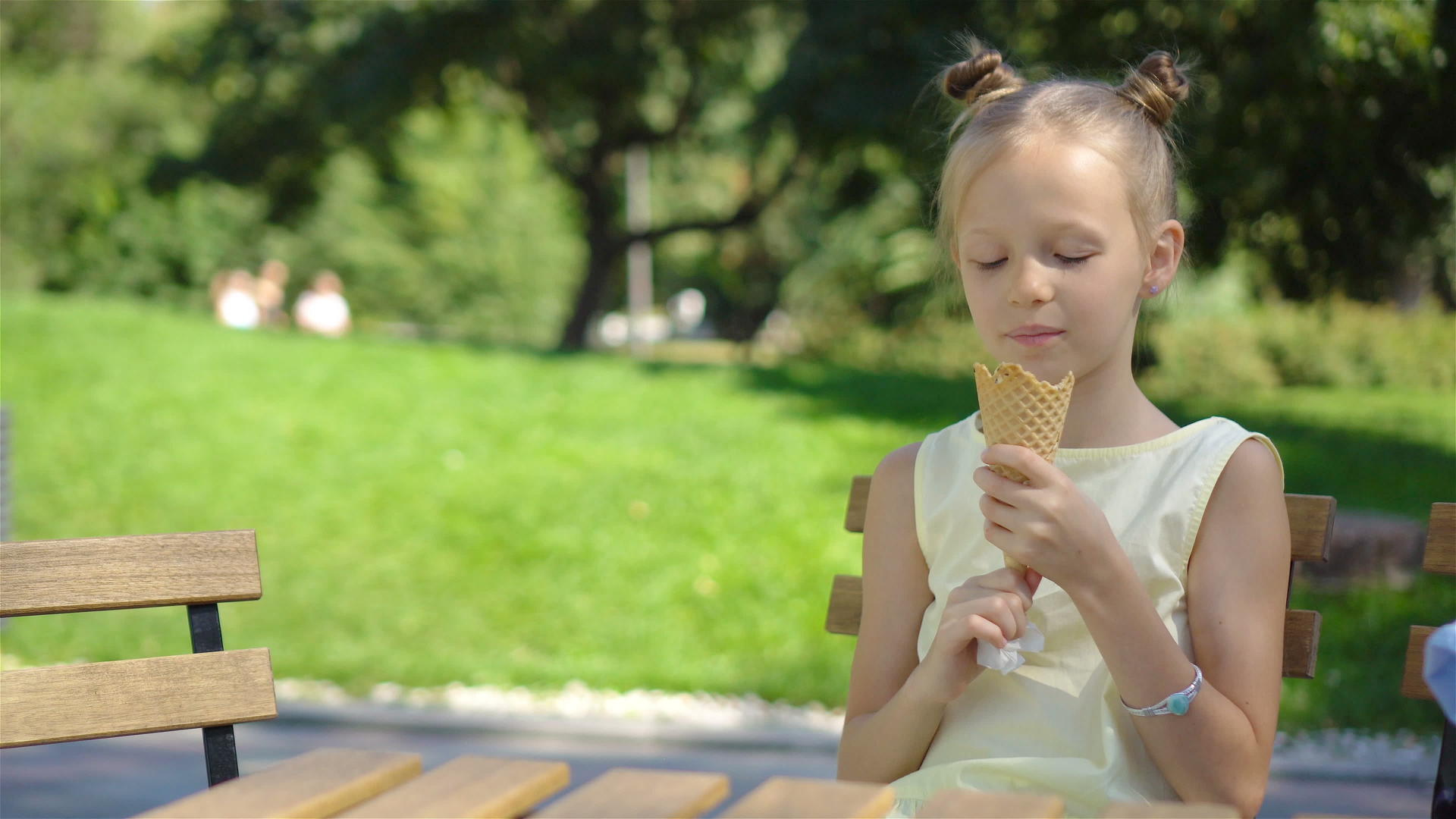 可爱的小女孩在夏天在户外咖啡馆吃冰淇淋享受真正的孩子视频的预览图