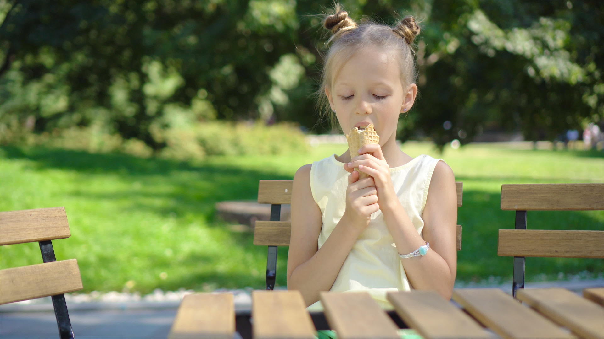 夏天在户外咖啡馆吃冰淇淋的小女孩视频的预览图
