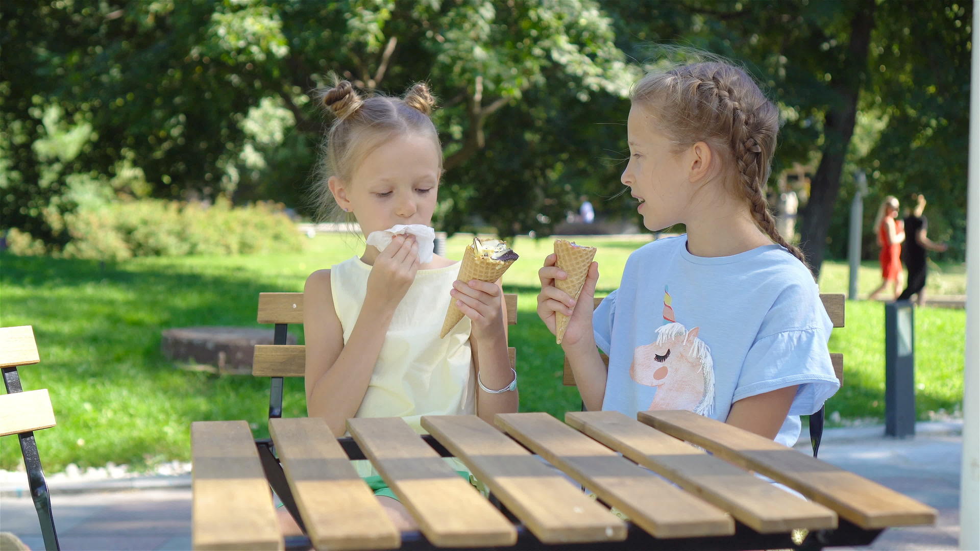 夏天在户外咖啡馆吃冰淇淋的小女孩们享受着真正的孩子视频的预览图