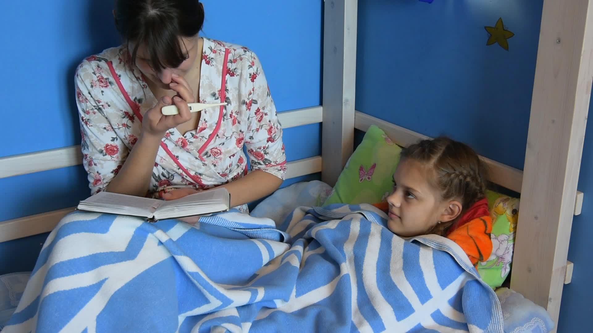 母亲坐在床上给一个生病的孩子读了一本书视频的预览图