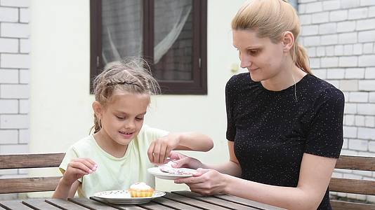 母亲和女儿在院子里呆了七年坐在东边蛋糕的桌子上视频的预览图