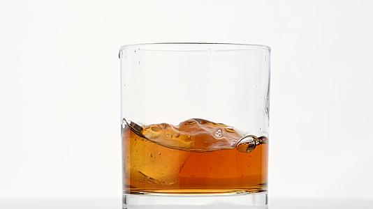 冰雪立方体倒入威士忌杯而不是白色视频的预览图