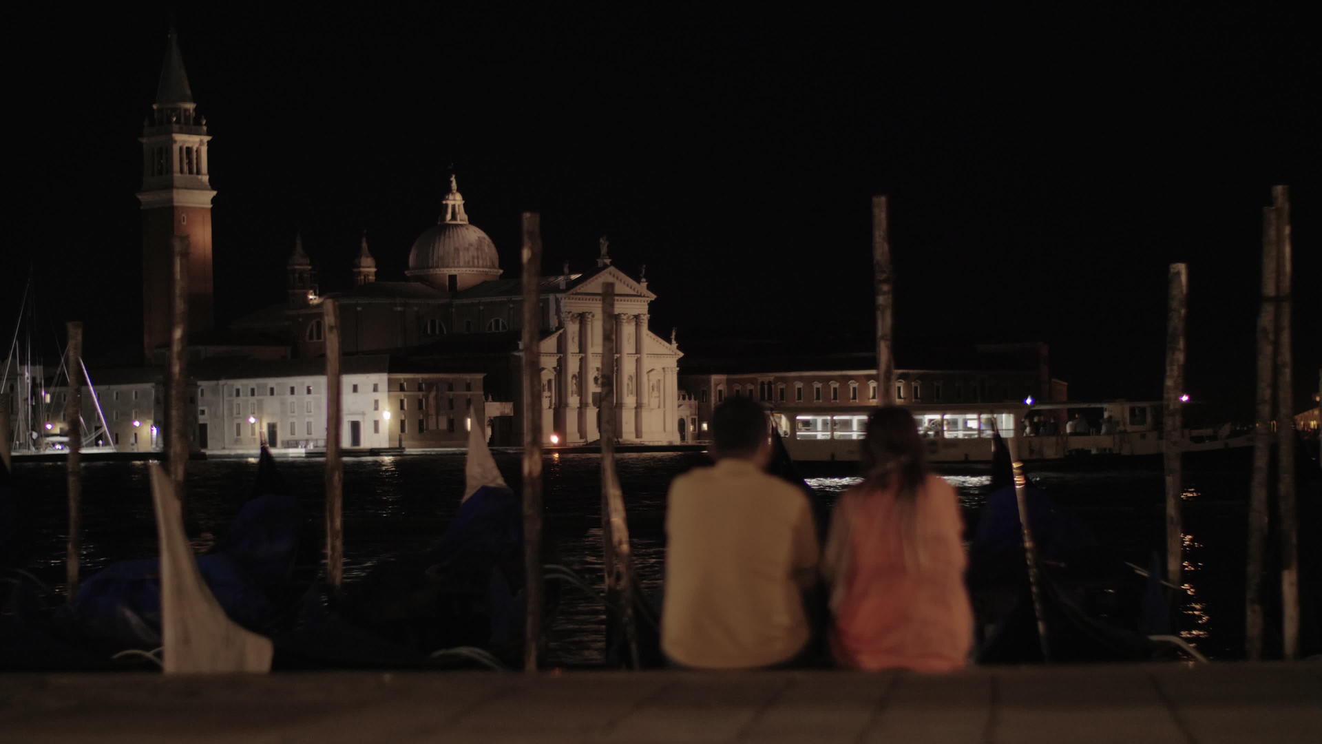 一对夫妇坐在岸边在夜晚的风景前视频的预览图