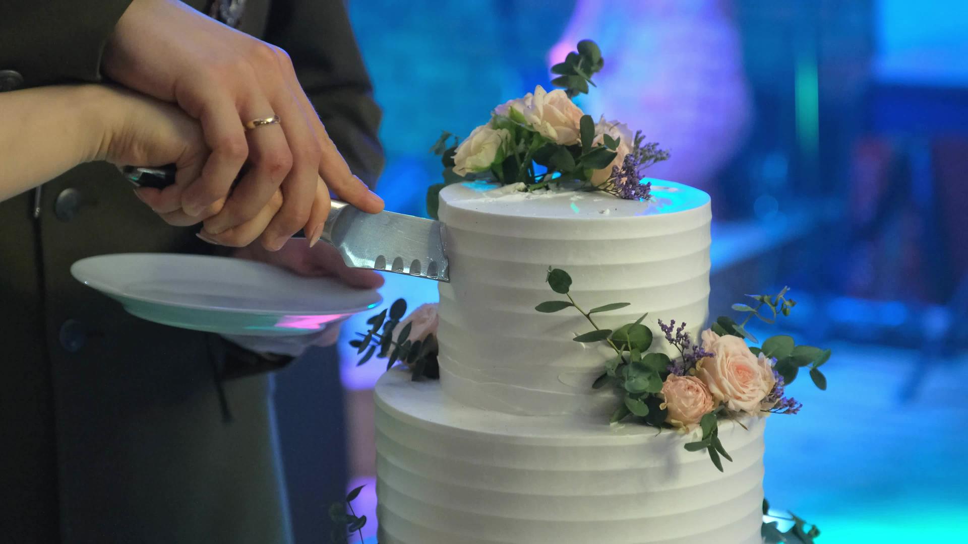 新婚夫妇正在切他们的第一块蛋糕视频的预览图