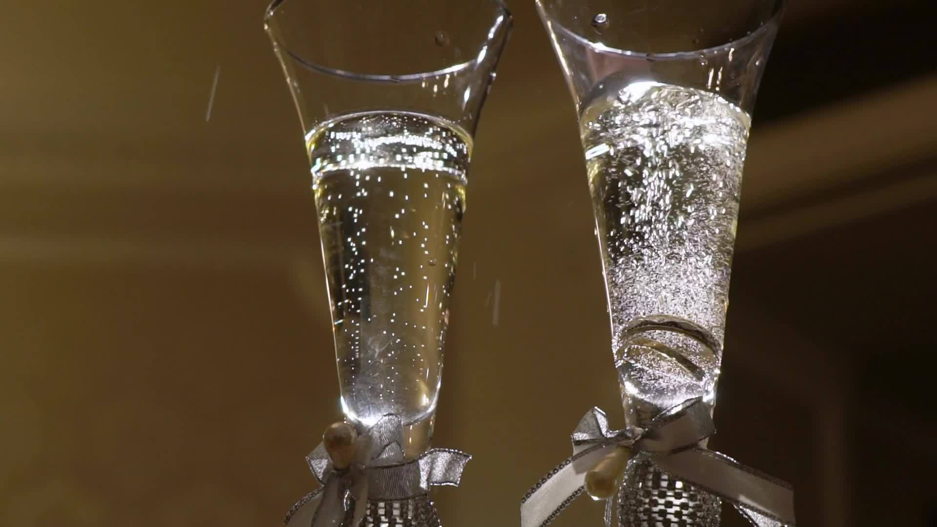 结婚戒指落在玻璃杯的香槟里视频的预览图