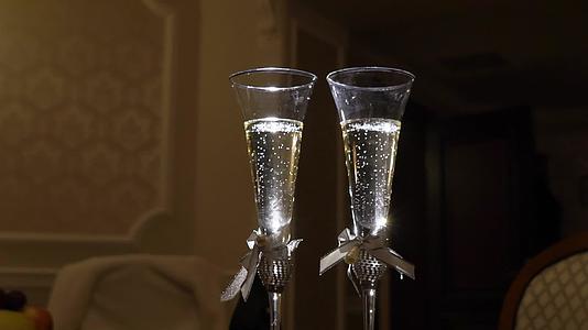结婚戒指落在玻璃杯上香槟慢慢变慢视频的预览图