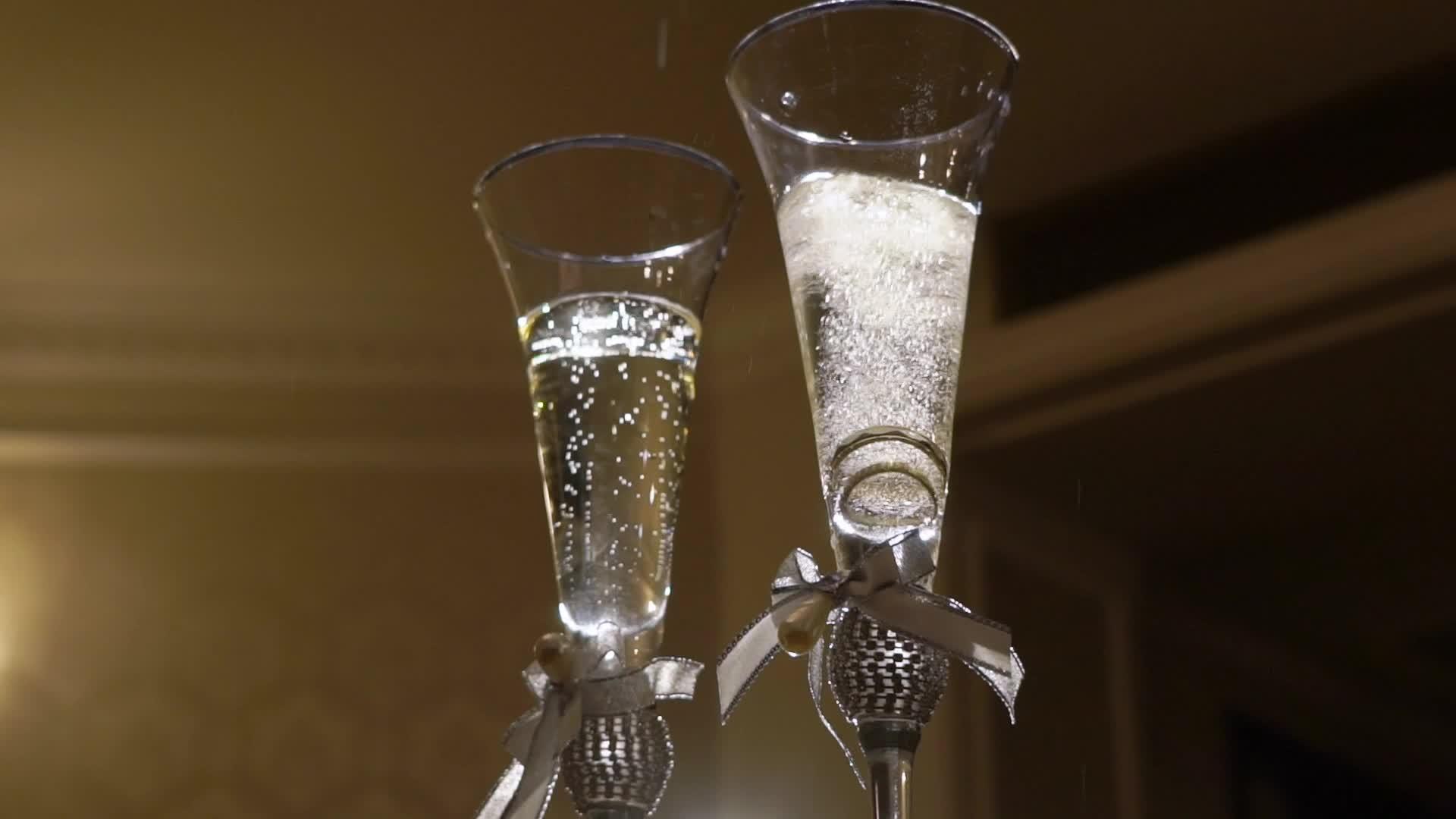 结婚戒指落在玻璃杯的香槟里视频的预览图