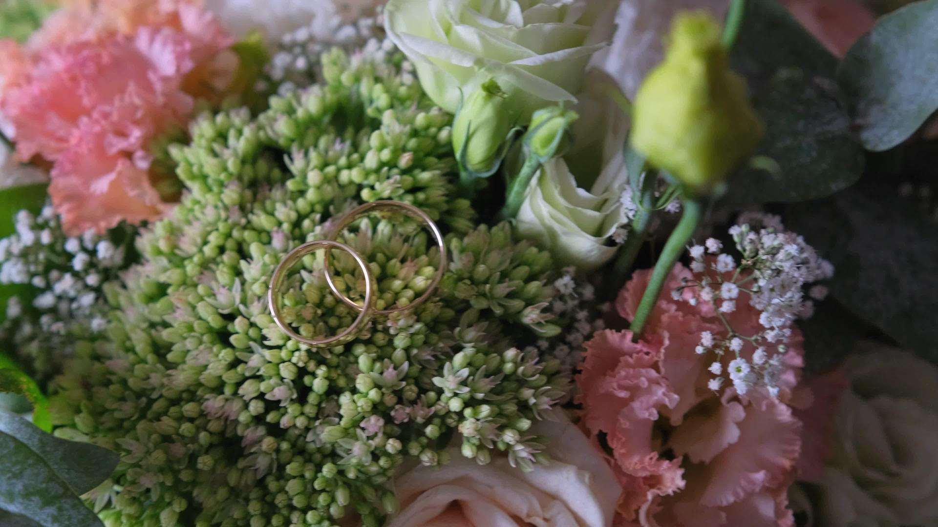 结婚戒指躺在花顶上视频的预览图