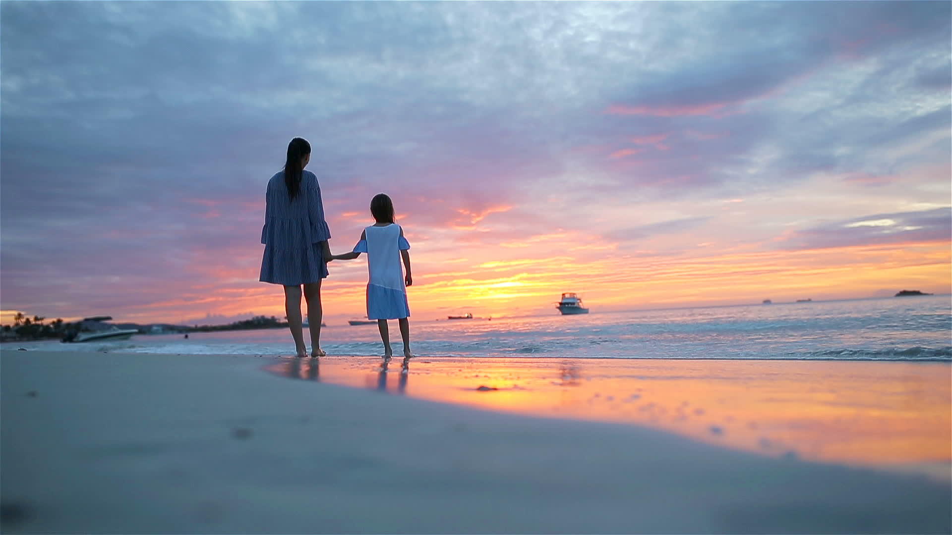 小女孩和爸爸在海滩日落时摇晃着小女儿和爸爸的脚影视频的预览图