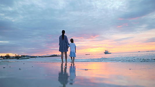 小女孩和爸爸在海滩上日落视频的预览图