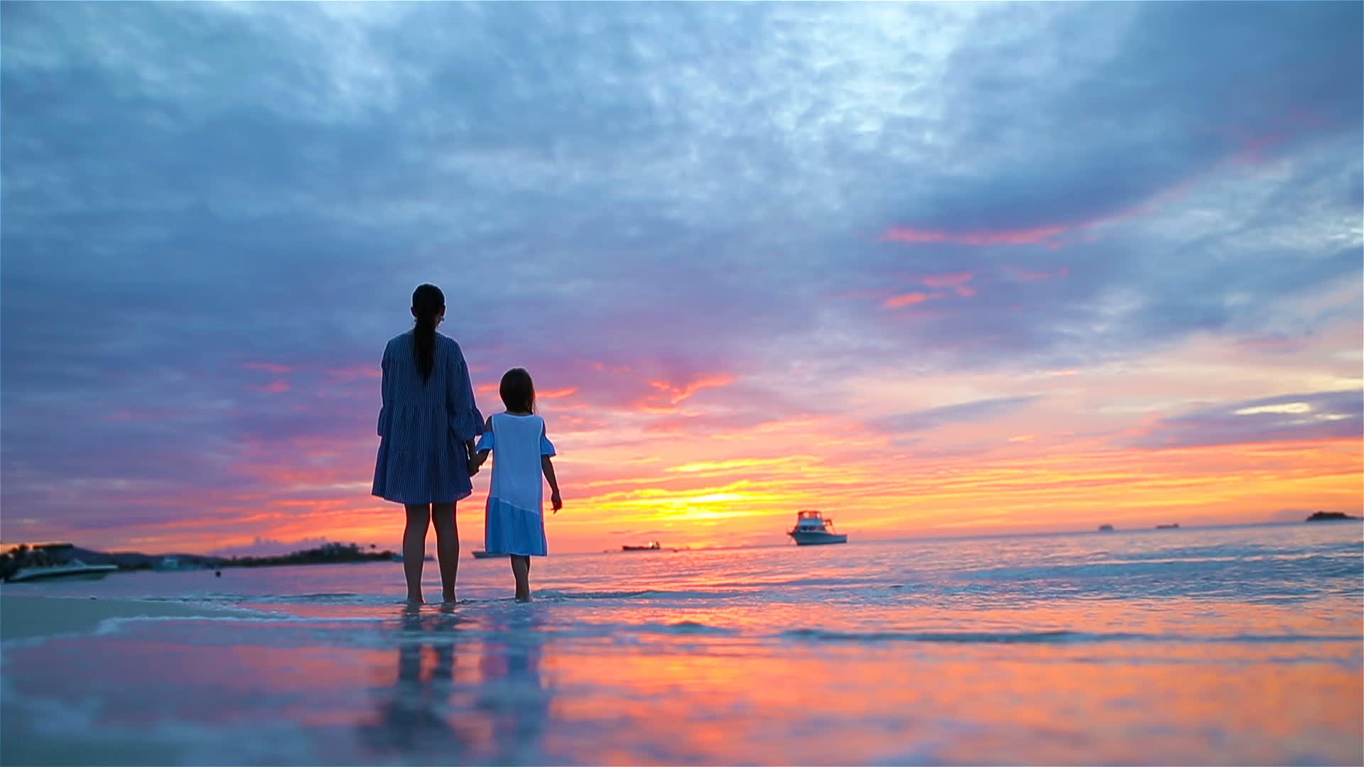 在美丽的海滩夕阳中 小女孩和快乐的母亲在地平线上的剪影视频的预览图