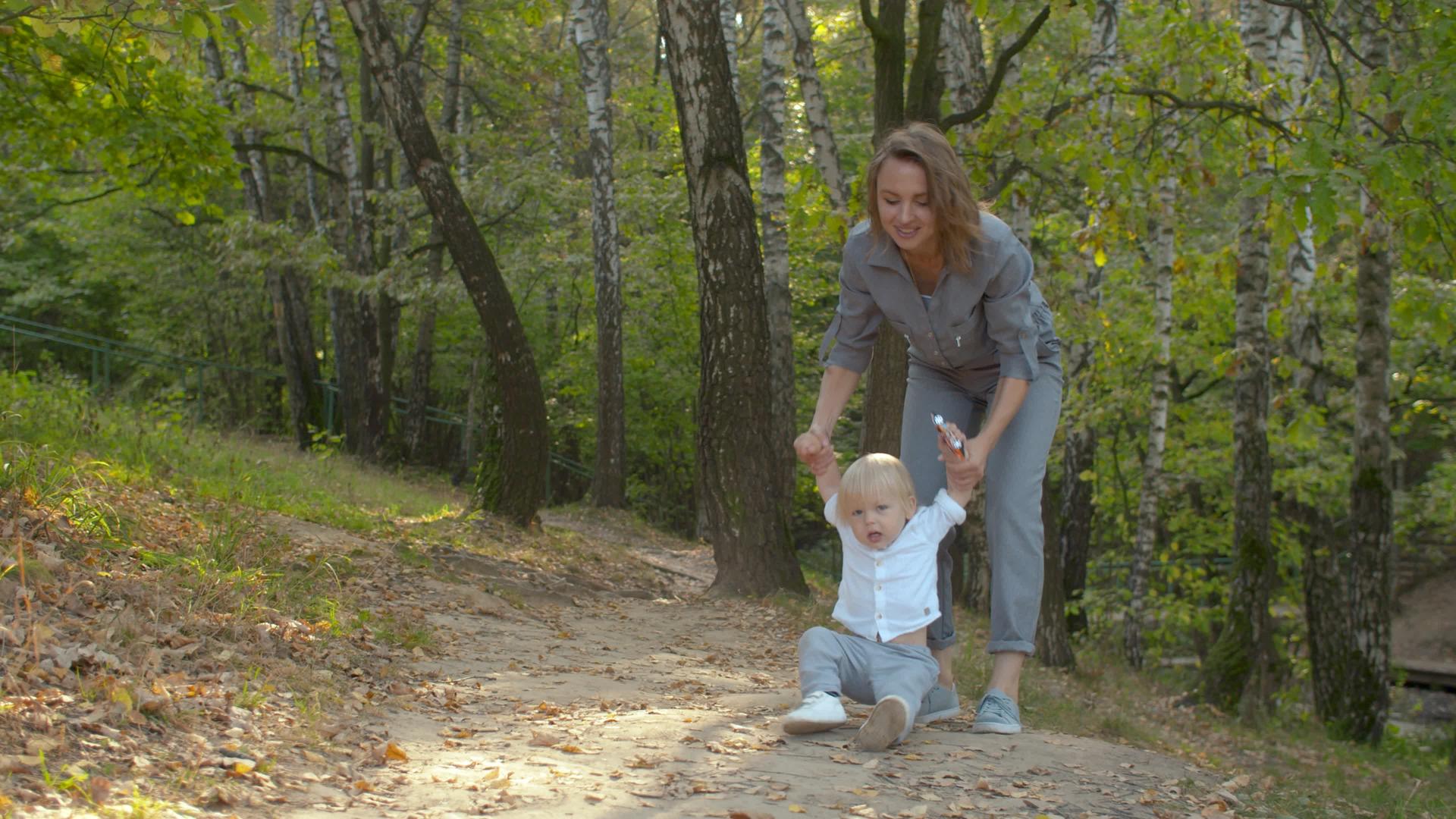 母亲和婴儿男孩在公园里散步视频的预览图