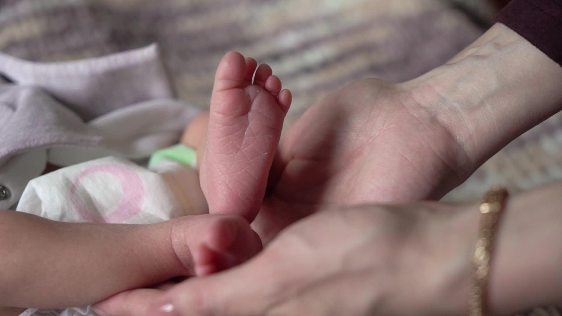 母亲抱着新生婴儿的腿视频的预览图