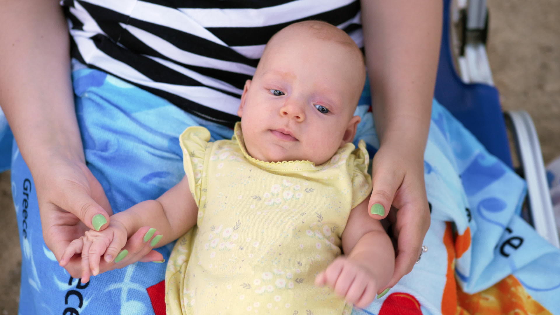 三个月大的婴儿在母亲的膝盖上视频的预览图