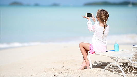 小女孩用相机拍摄视频或照片坐在阳光下视频的预览图