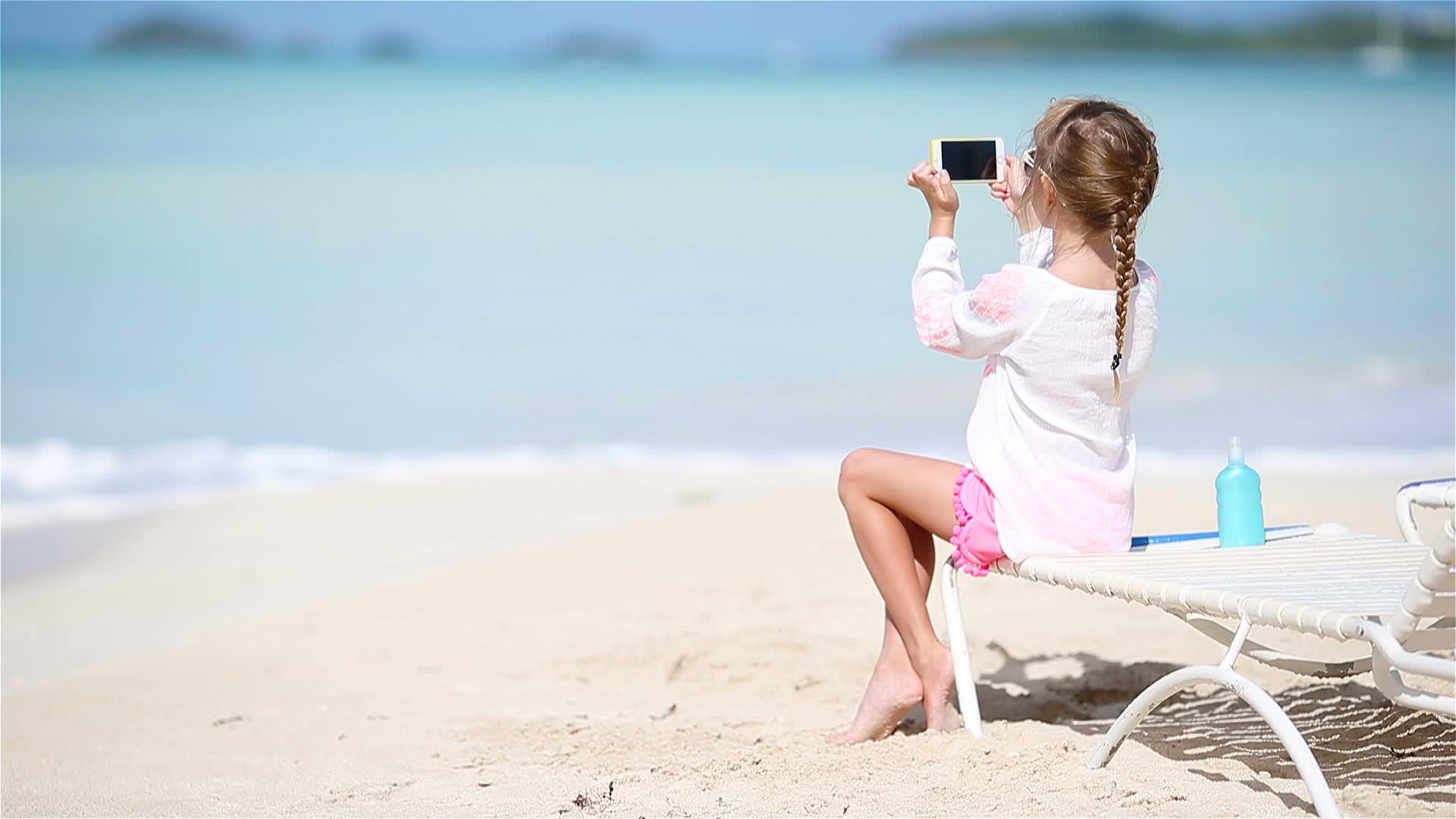 小女孩坐在沙威隆格上用她的相机拍摄视频或照片视频的预览图