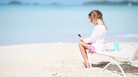 小女孩用相机拍摄视频或照片坐在阳光下视频的预览图