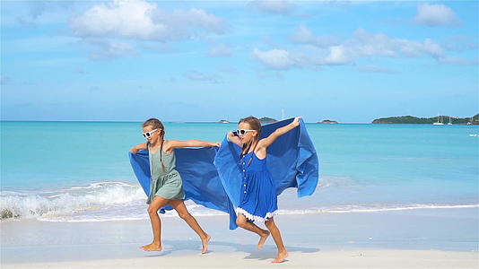 小女孩在热带度假期间享受海滩毛巾的乐趣视频的预览图