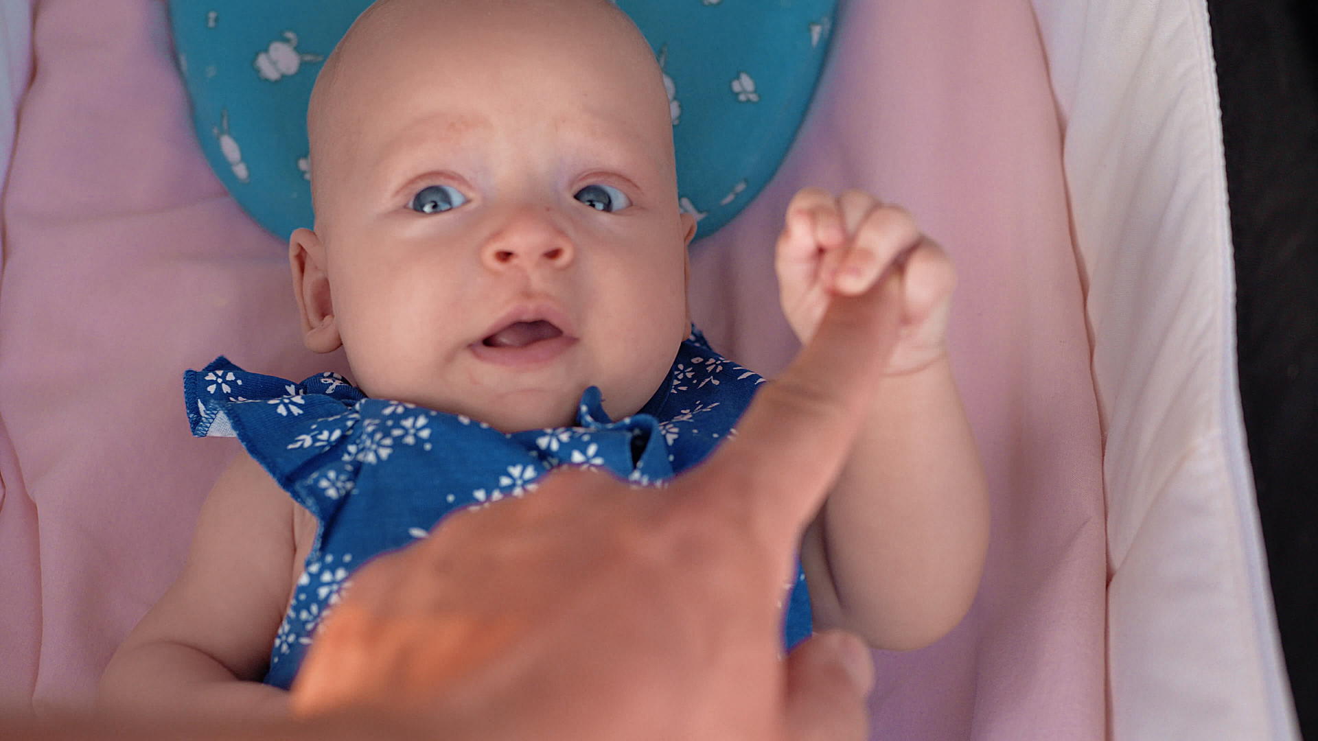 抱着父亲的手指躺在婴儿床上视频的预览图