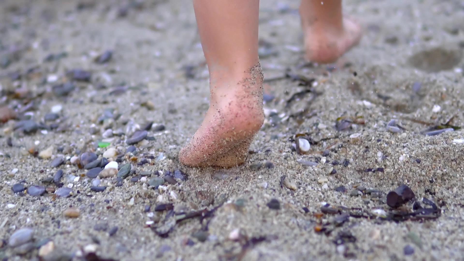 母亲和婴儿在石头在沙滩上行走Standicam视频的预览图