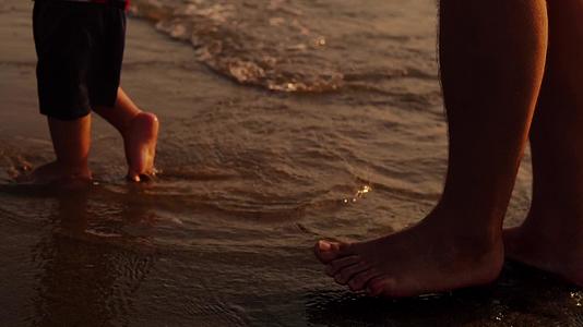 在海滩的金色海滩上上海的日落溅起了婴儿的脚视频的预览图