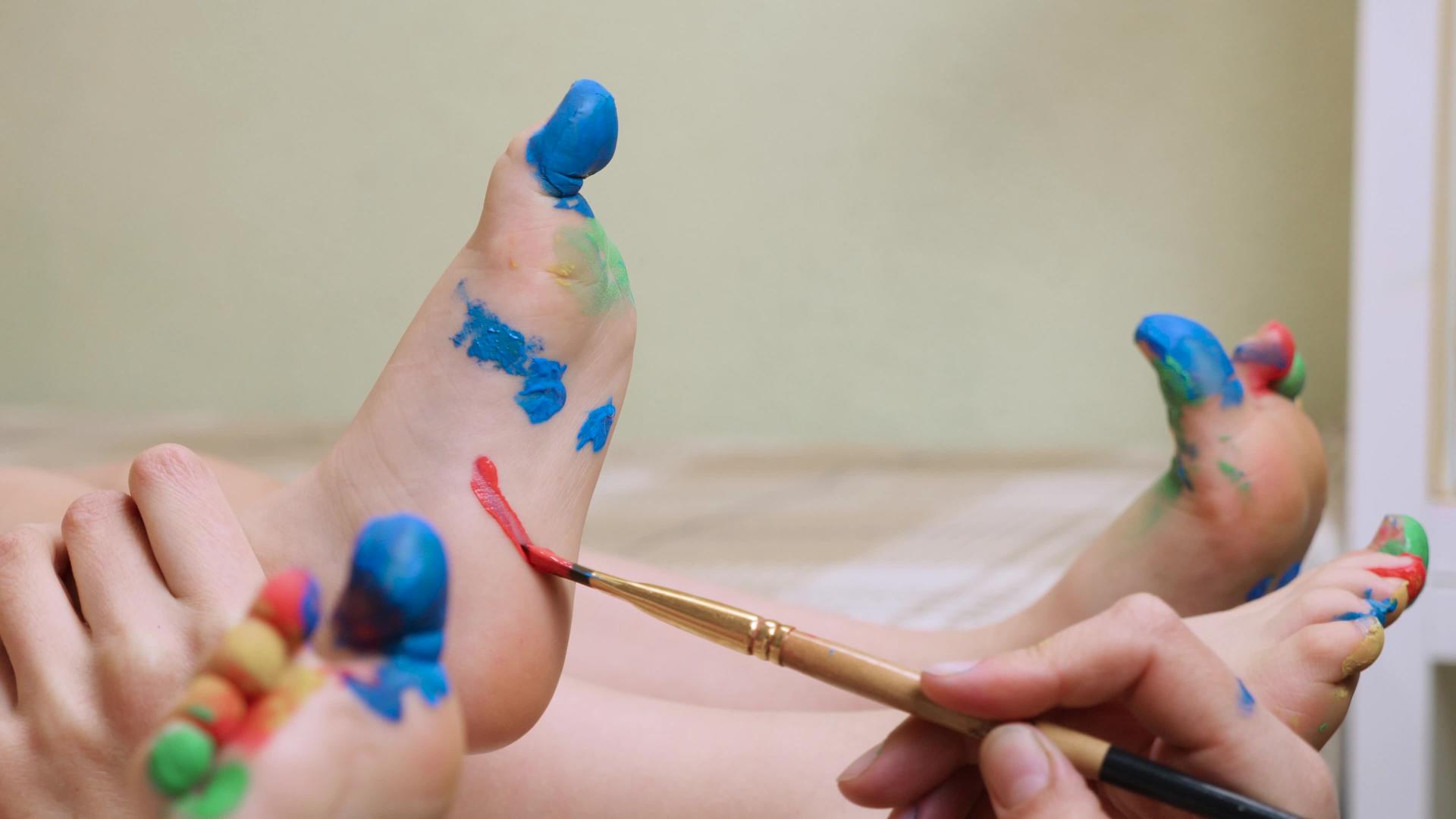 婴儿艺术疗法孩子在腿上画脸 孩子在脚上画微笑和特写感官视频的预览图