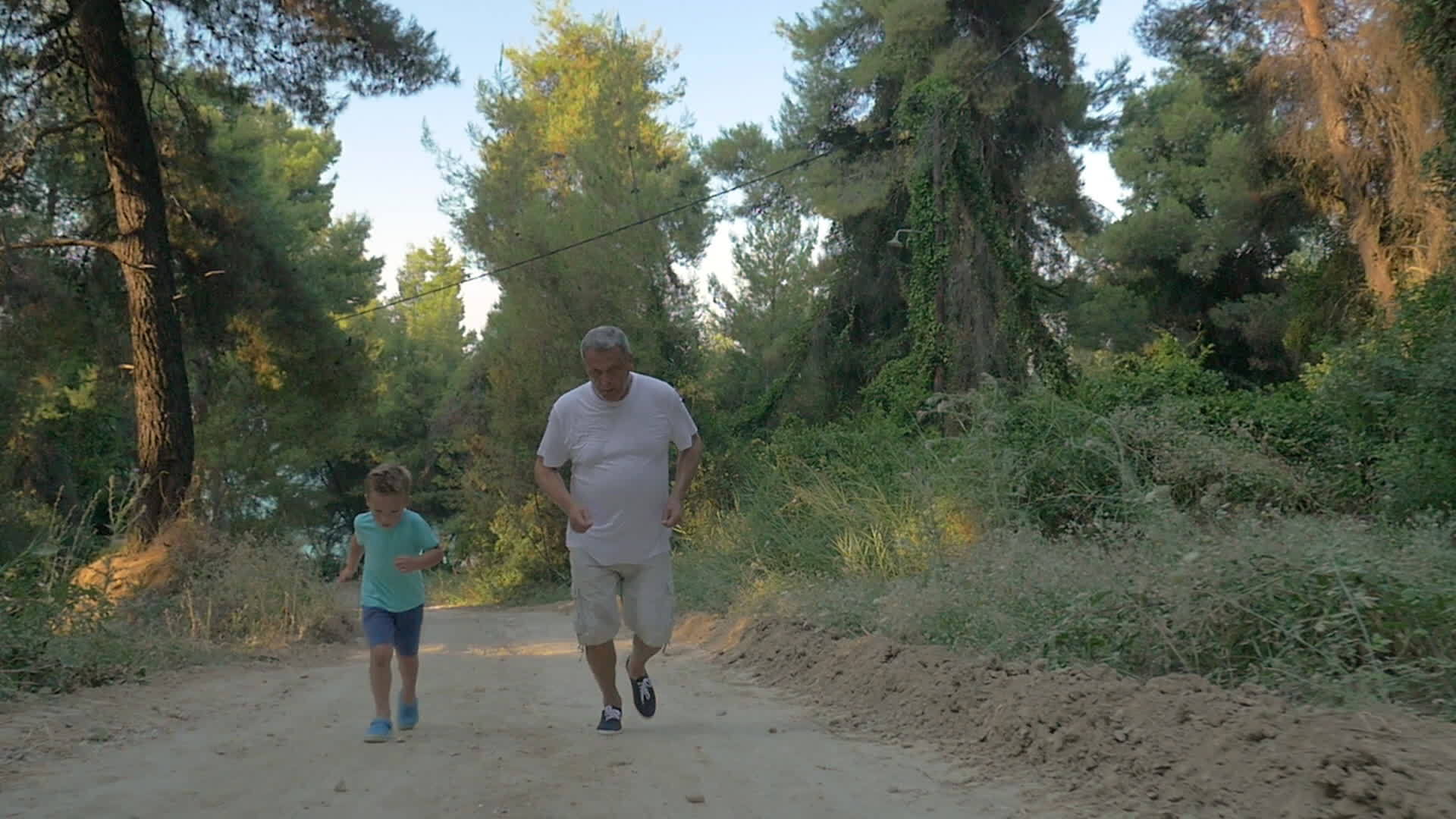 祖父和孙子在森林里慢跑视频的预览图