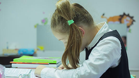 女孩写作和做家庭作业视频的预览图
