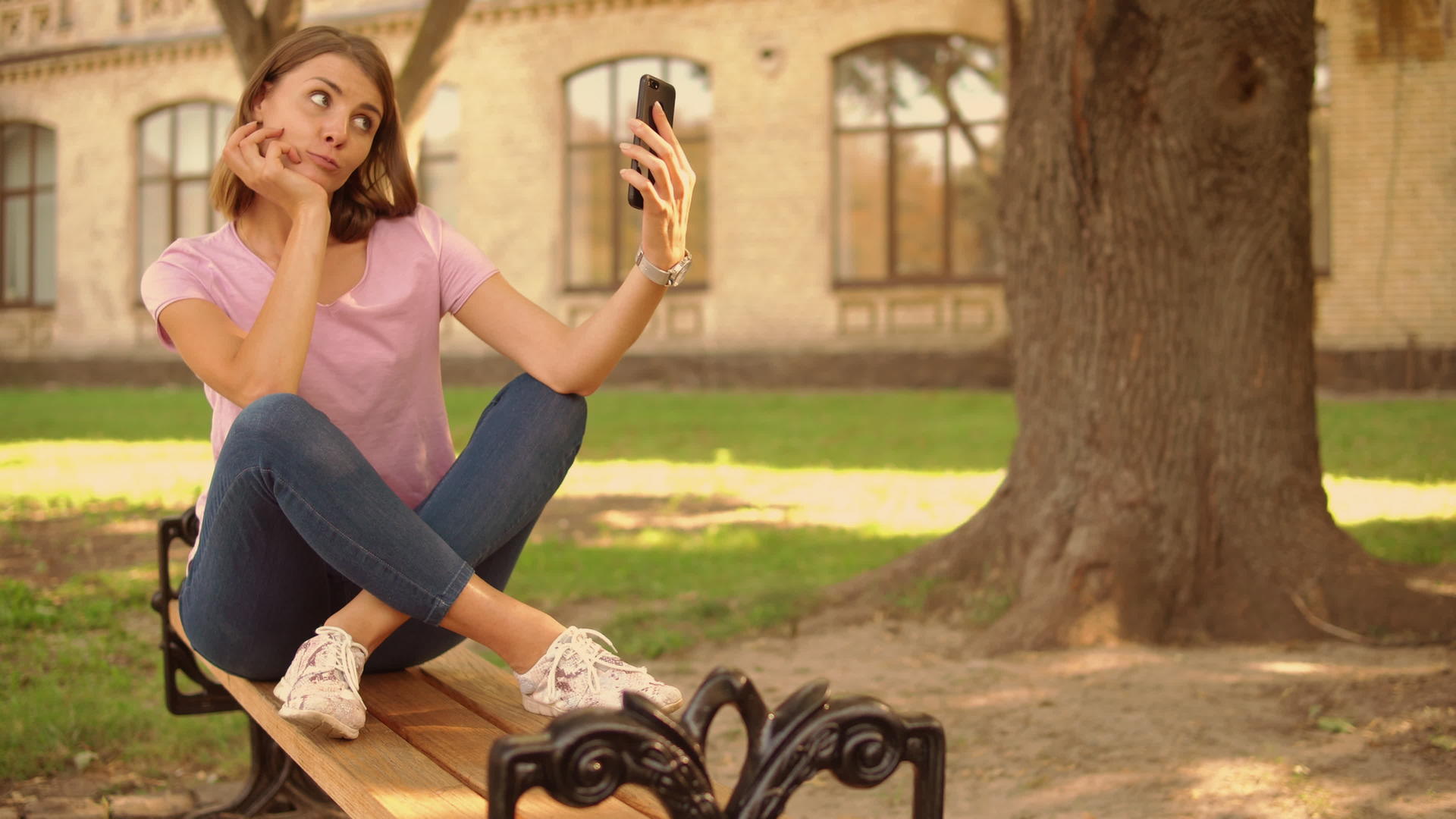 这位年轻女子在大学附近的手机上拍照视频的预览图