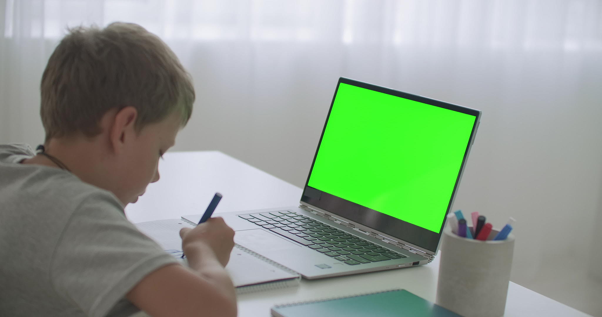 小男孩正在远程学习在笔记本电脑上看视频用铅笔染色身体视频的预览图