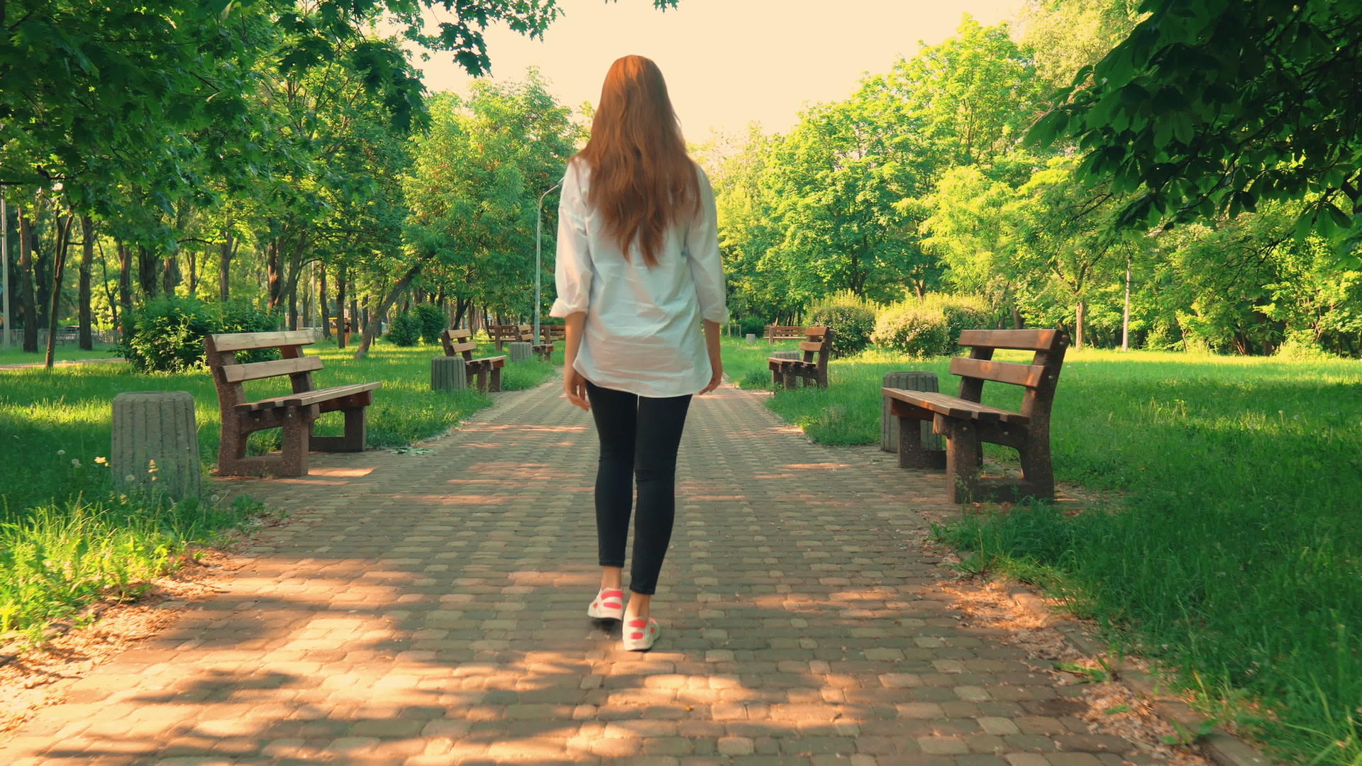 红发女孩在公园里散步白天在夏天散步视频的预览图