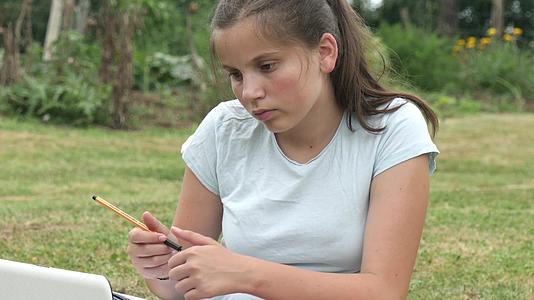 青少年在花园里做家庭作业视频的预览图
