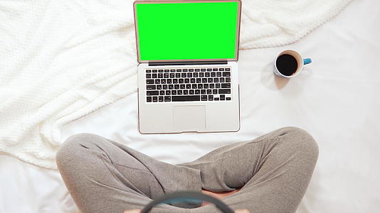 男人坐在床上打字电脑的顶部视频的预览图