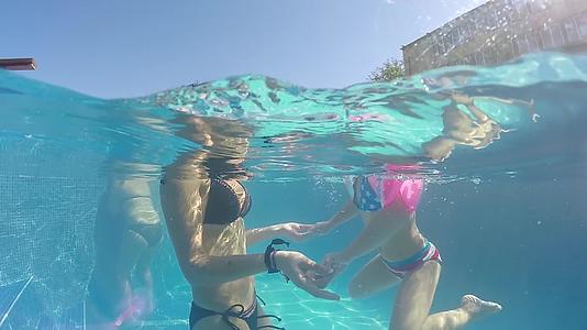 放松和温泉概念母亲和女孩拥抱在水中漂浮在水下视频的预览图
