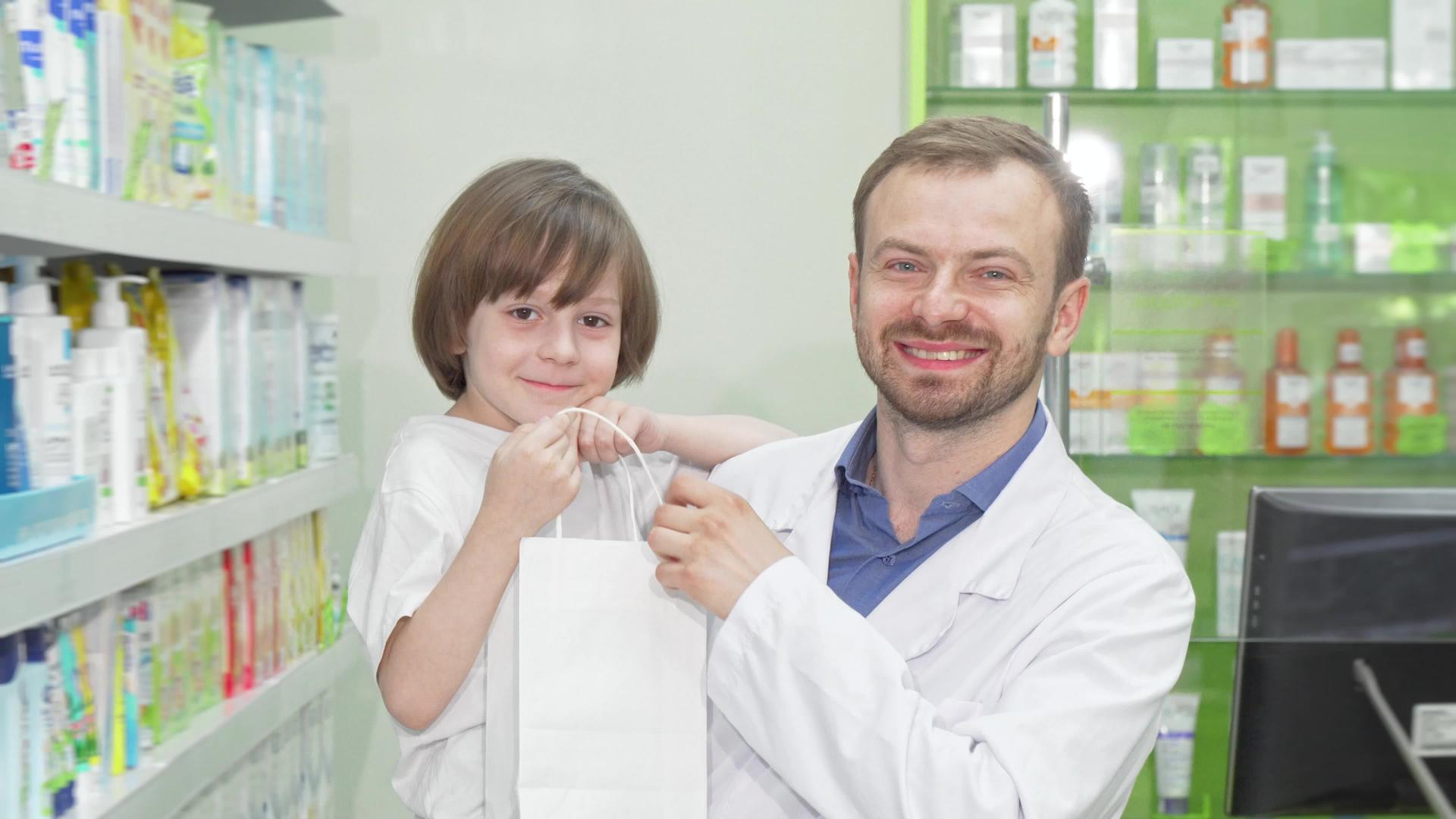 快乐的药剂师和可爱的小男孩对着镜头微笑视频的预览图