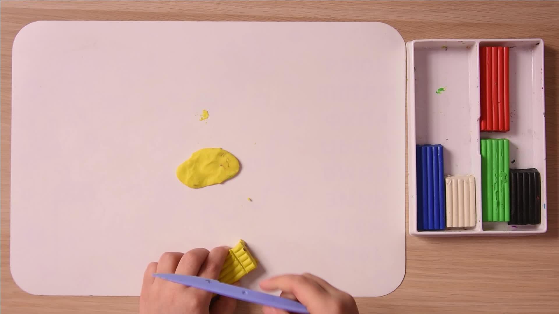 孩子切下一块黄色的塑料来缝合顶部的视图视频的预览图