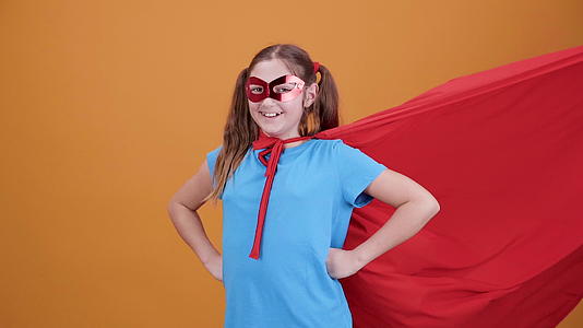 一个非常积极的女孩伪装成电影中的超级英雄在镜头前微笑视频的预览图