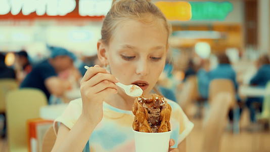 美丽的女孩吃冰淇淋花芙咖啡厅视频的预览图