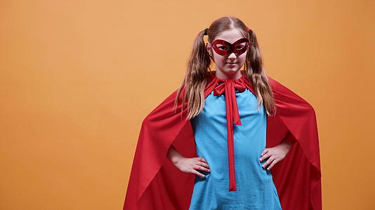 一个穿着超级英雄服装的女孩对着镜头微笑视频的预览图