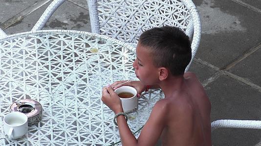 快乐的学校男孩在游泳池边喝健康茶视频的预览图