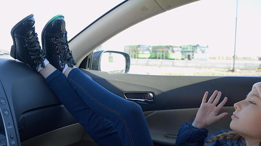年轻女孩坐在车里听音乐视频的预览图