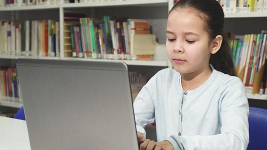 亚洲美丽的小女孩在笔记本电脑上学习视频的预览图