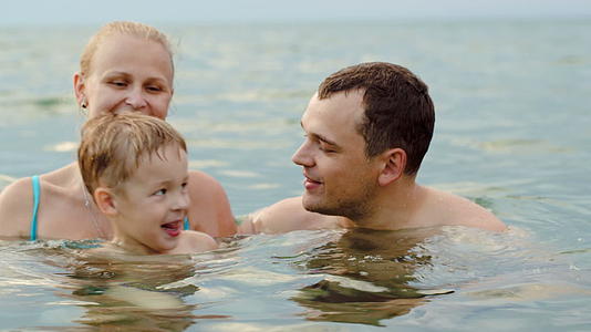 一个可爱的家庭有孩子在海里洗澡视频的预览图