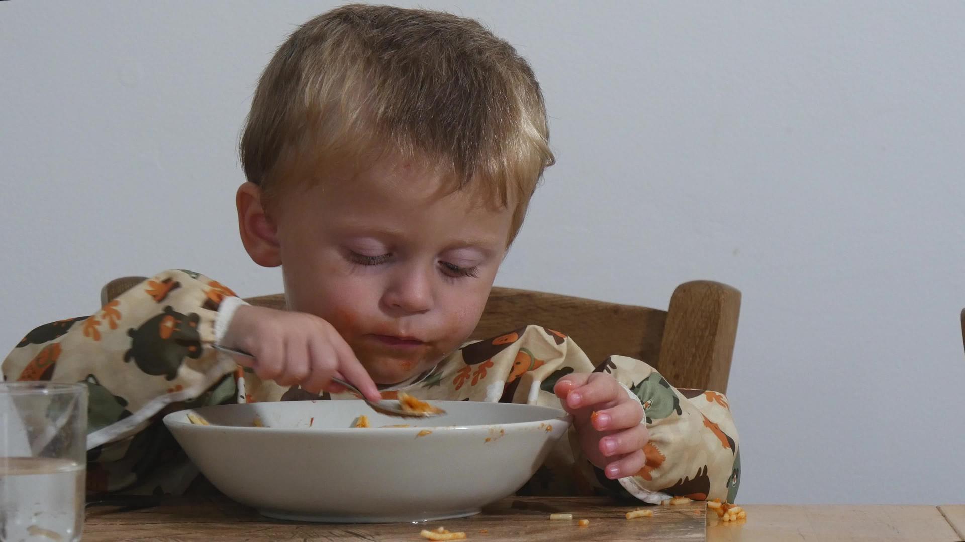 这个可爱的小男孩在室内吃了两年的意大利面视频的预览图