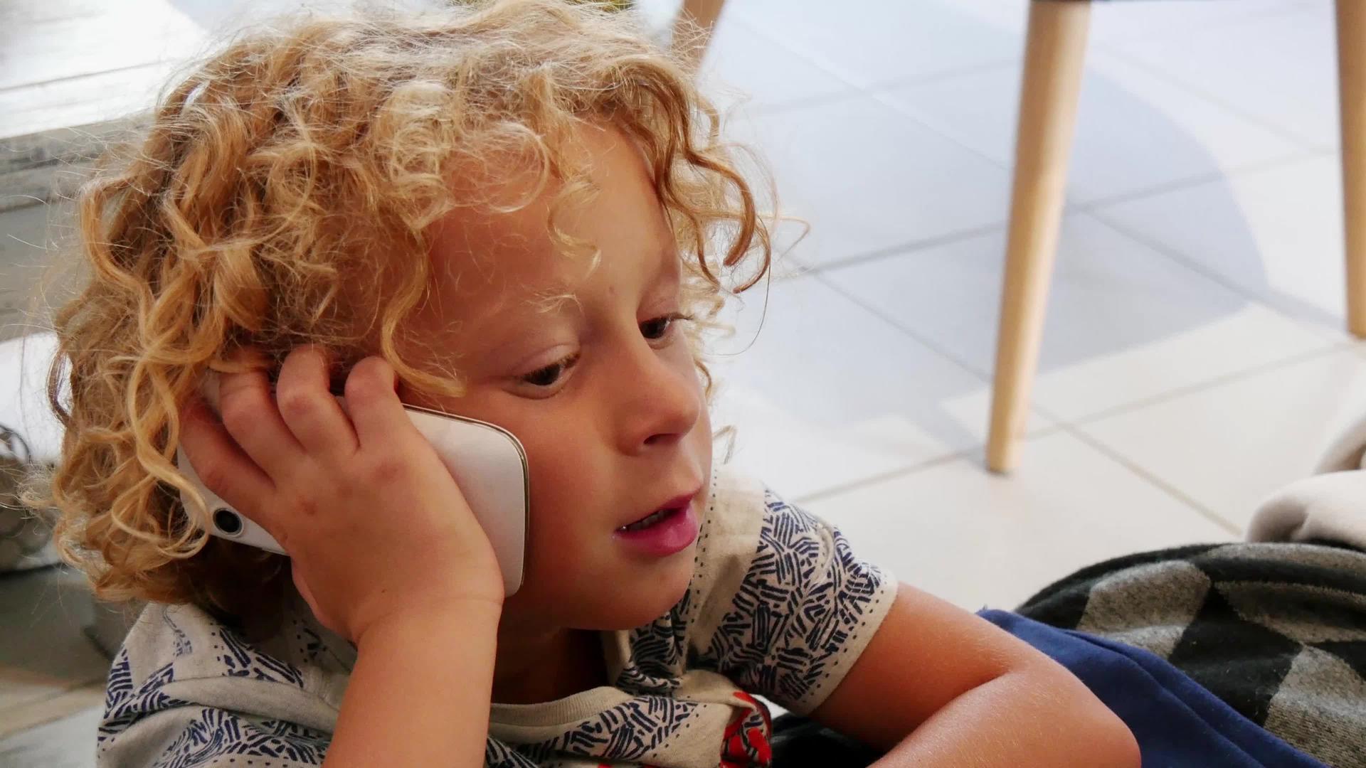 小金发男孩玩智能手机视频的预览图