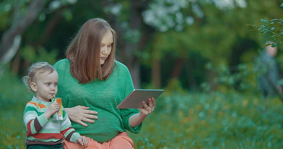 怀孕的母亲和儿子使用公园垫子视频的预览图
