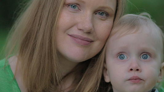 年轻的母亲和可爱的小儿子的户外肖像视频的预览图