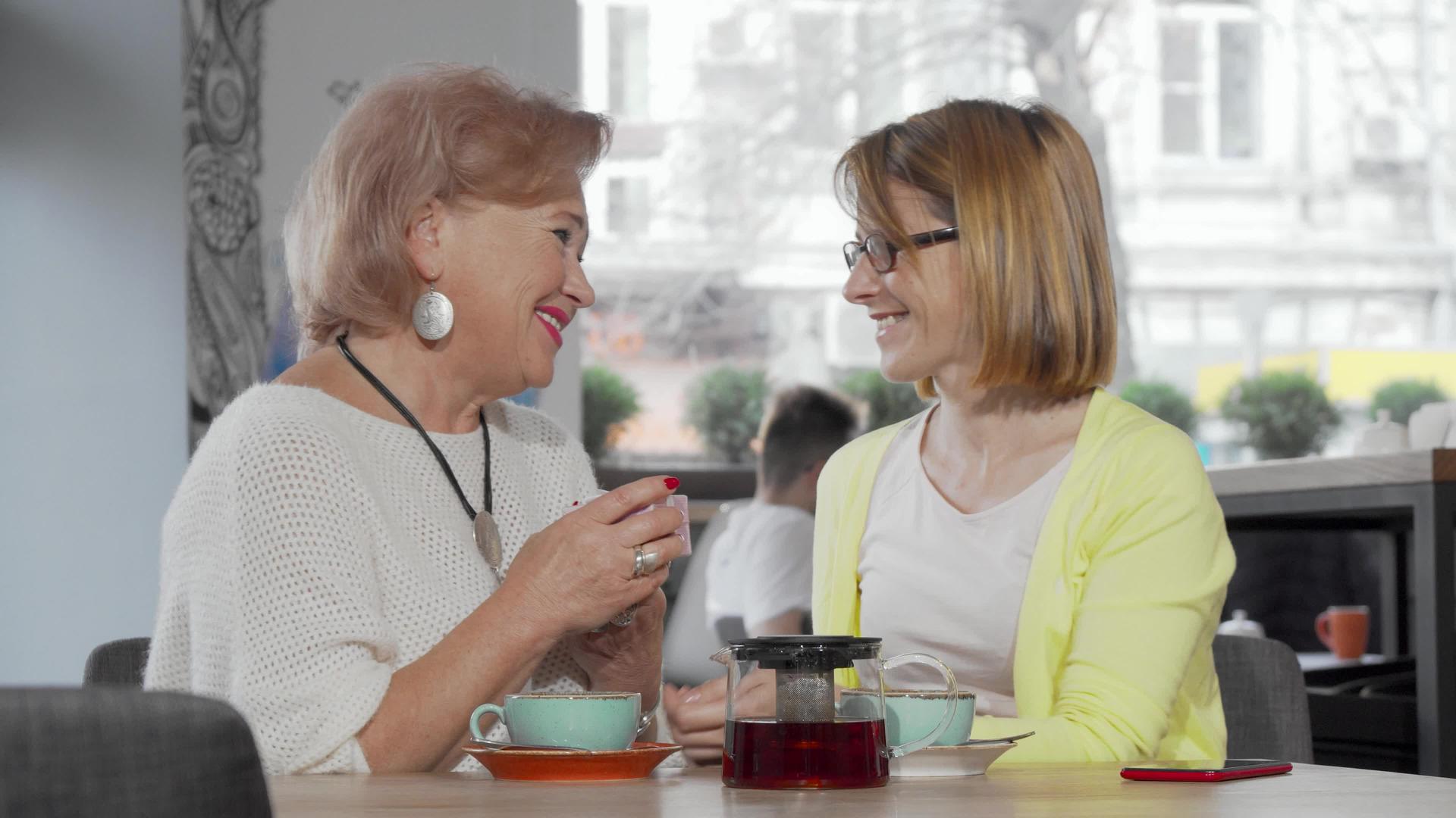 成年妇女在咖啡店给年长的母亲送礼物视频的预览图